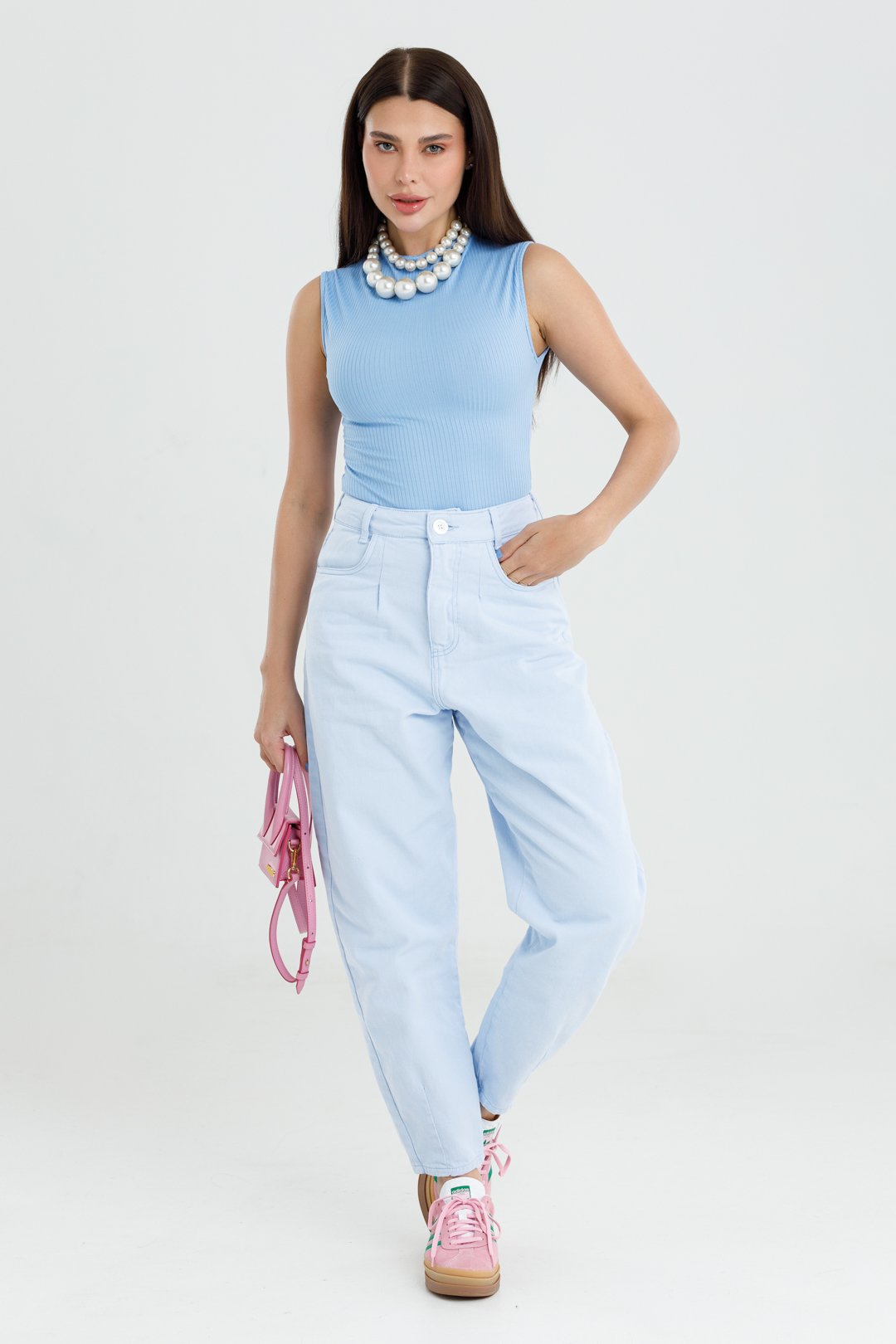 Detalhe da calça Cassia azul bebê de sarja com cintura alta, pregas e mão no bolso frontal
