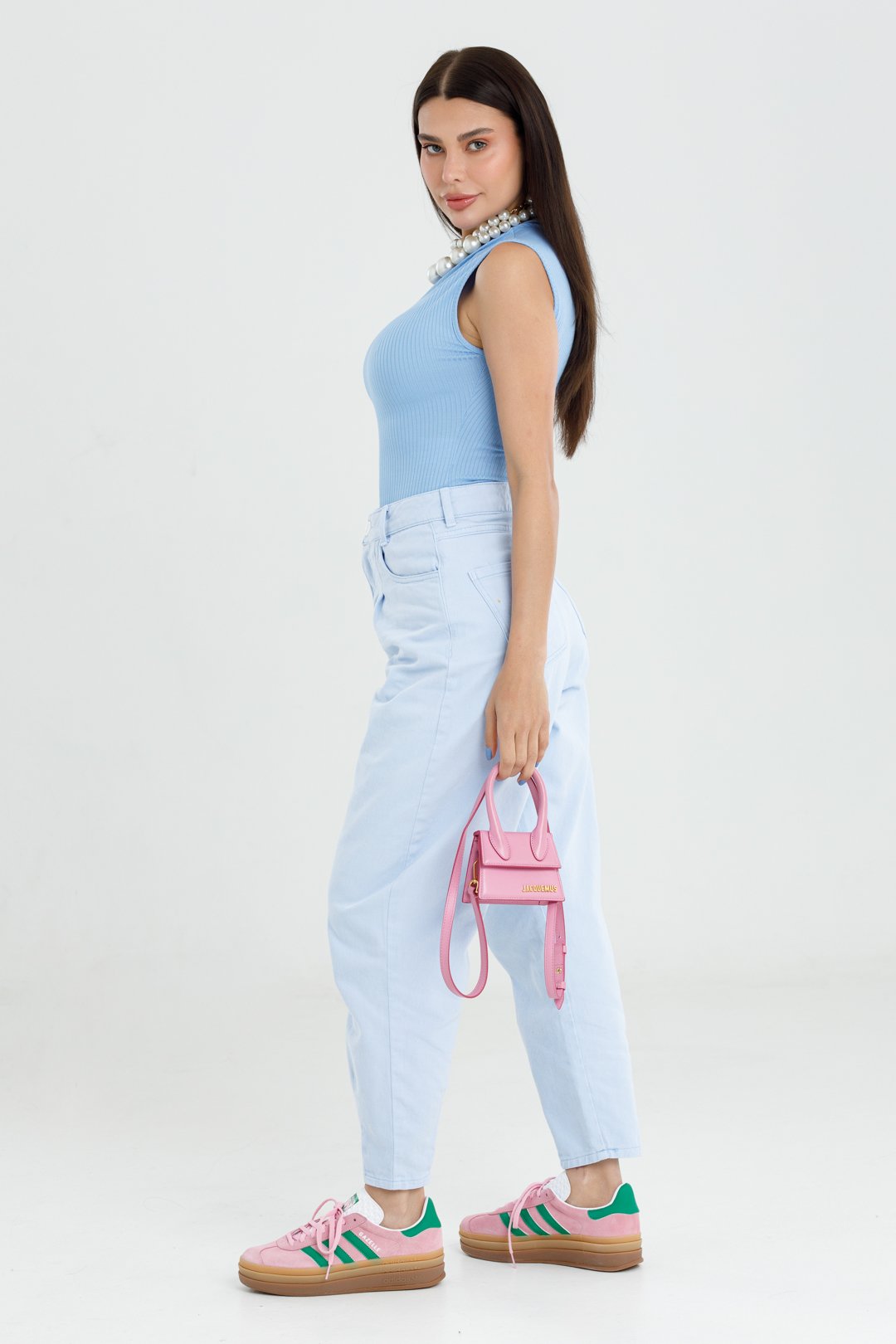 Modelo de corpo inteiro com a calça Cassia azul bebê, body canelado azul claro e tênis rosa