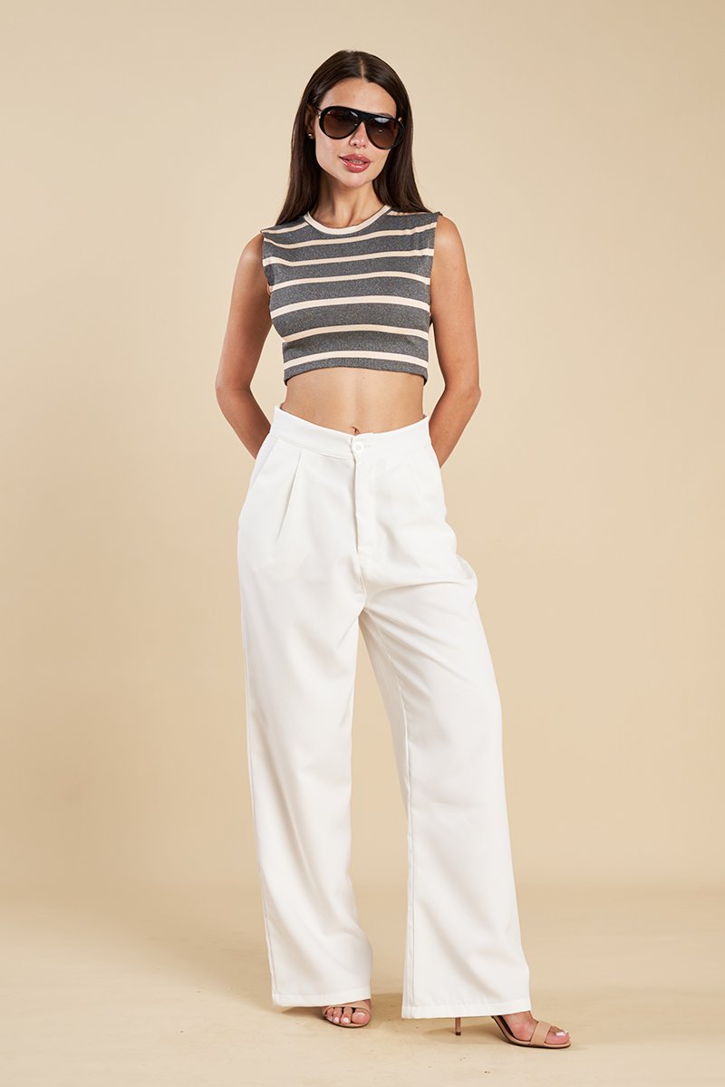Regata cropped listrada usada com calça branca de alfaiataria e óculos escuros