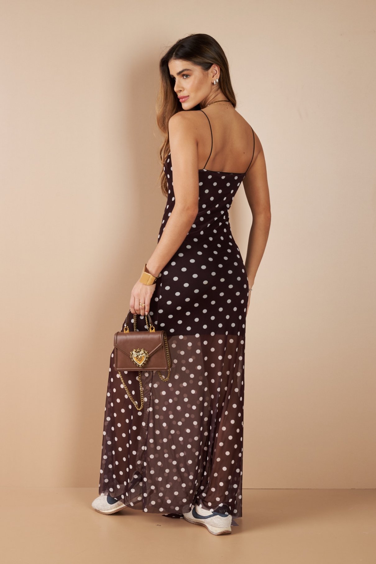 Vestido longo de poá marrom em detalhe, mostrando a barra de tule transparente e o forro terminando abaixo do joelho.