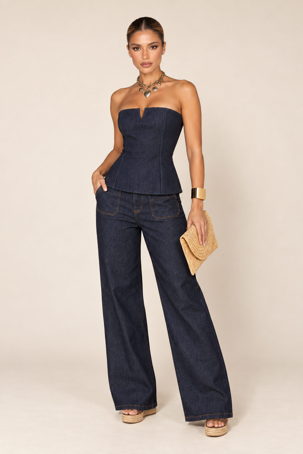 Modelo usa o tomara que caia de jeans índigo com calça jeans escura e colar dourado.