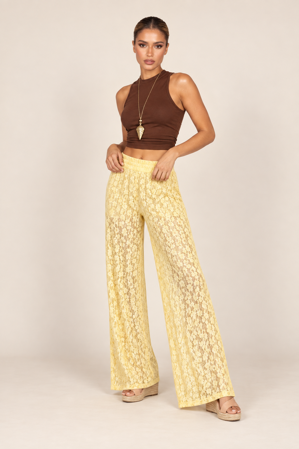 Modelo usando a pantalona de renda amarela com cropped marrom e plataforma de corda