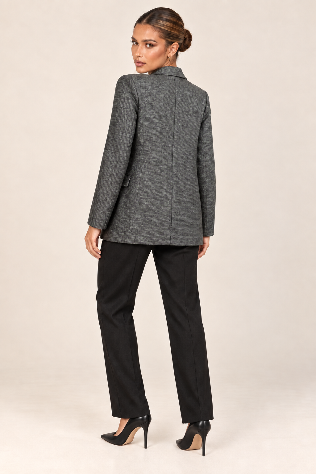 Modelo usando o blazer cinza de um botão com blusa branca, calça preta de alfaiataria e scarpin preto