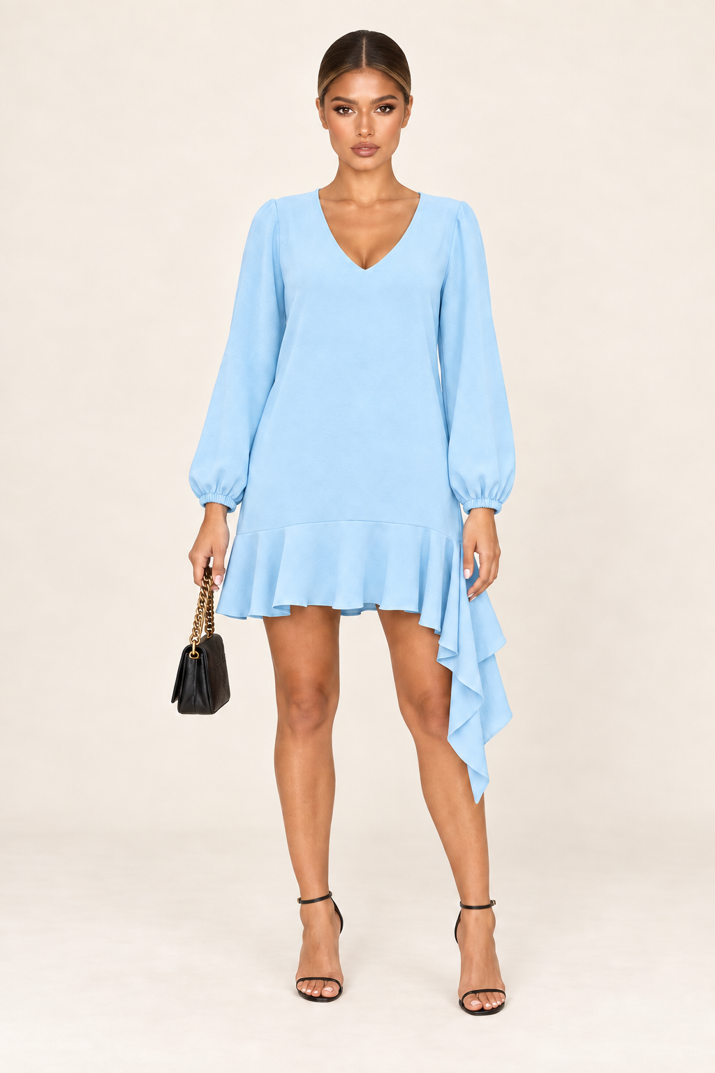 Vestido curto azul bebê fotografado sozinho em fundo claro, com decote em V, mangas bufantes e babado assimétrico na barra